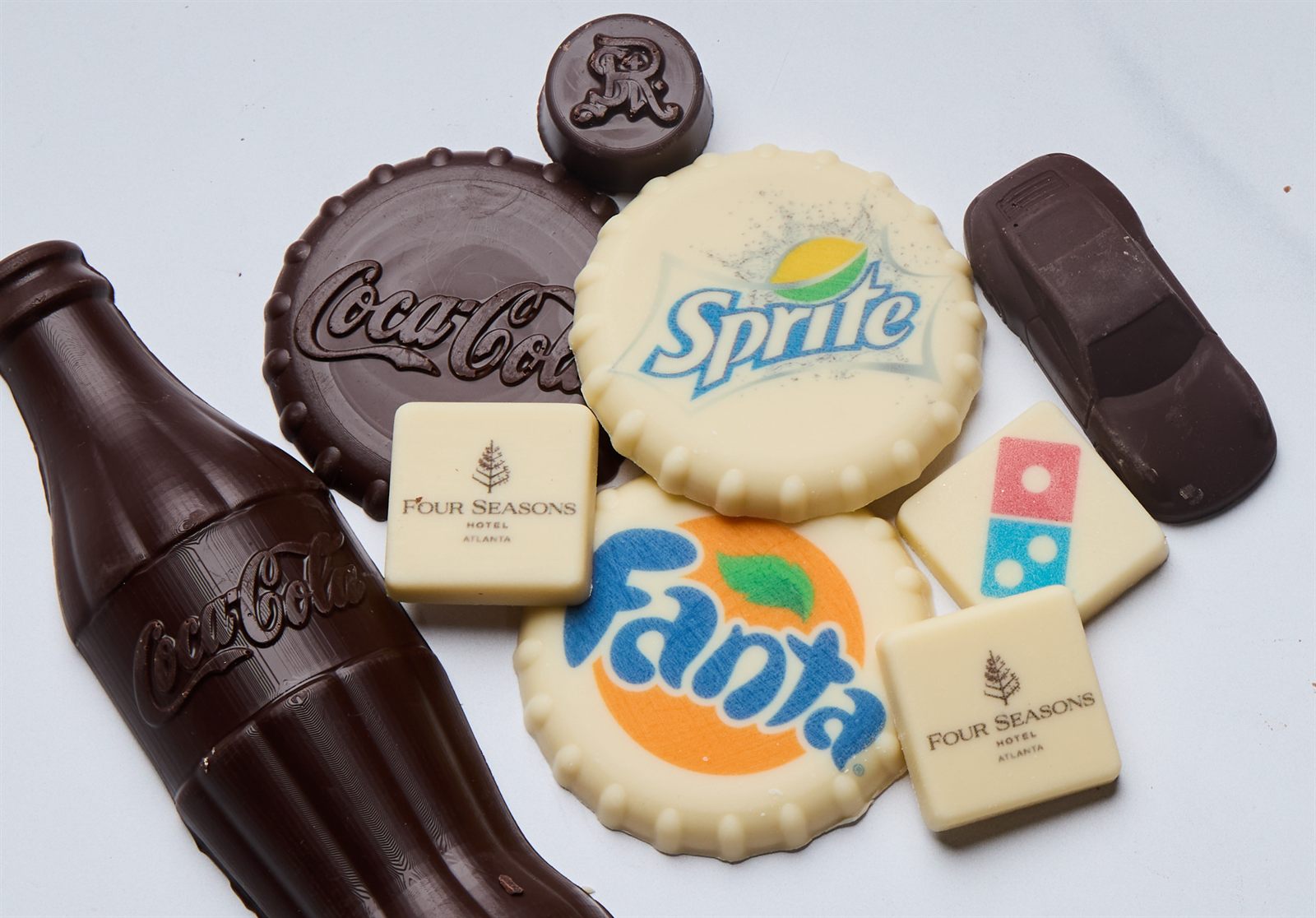 Chocolate molded and printed with brand logos including Coca-Cola, Sprite, Fanta, Four Seasons, and Domino's